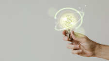 Green Energy With Hand Holding Environmental Light Bulb Background (1)